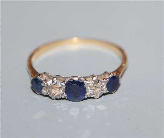 An 18ct, graduated sapphire and diamond five stone half hoop ring, size P.